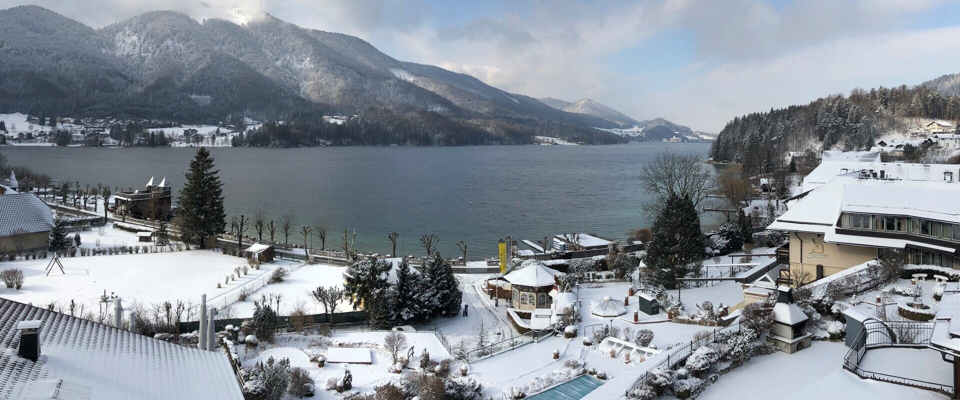 Das 4* Superior Wellnesshotel Ebner's Waldhof am Fuschlsee mit Schnee und Außenpool.