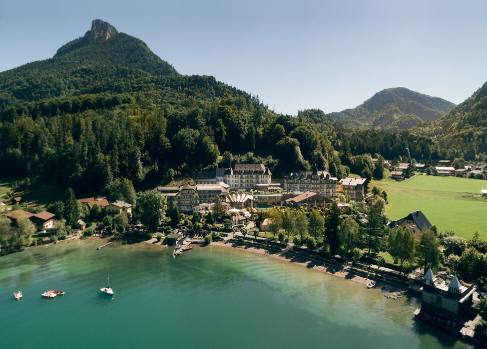 Panoramablick auf das 4 Sterne Superior Hotel Ebner's Waldhof am See mit dem Fuchlsee im Vordergrund.